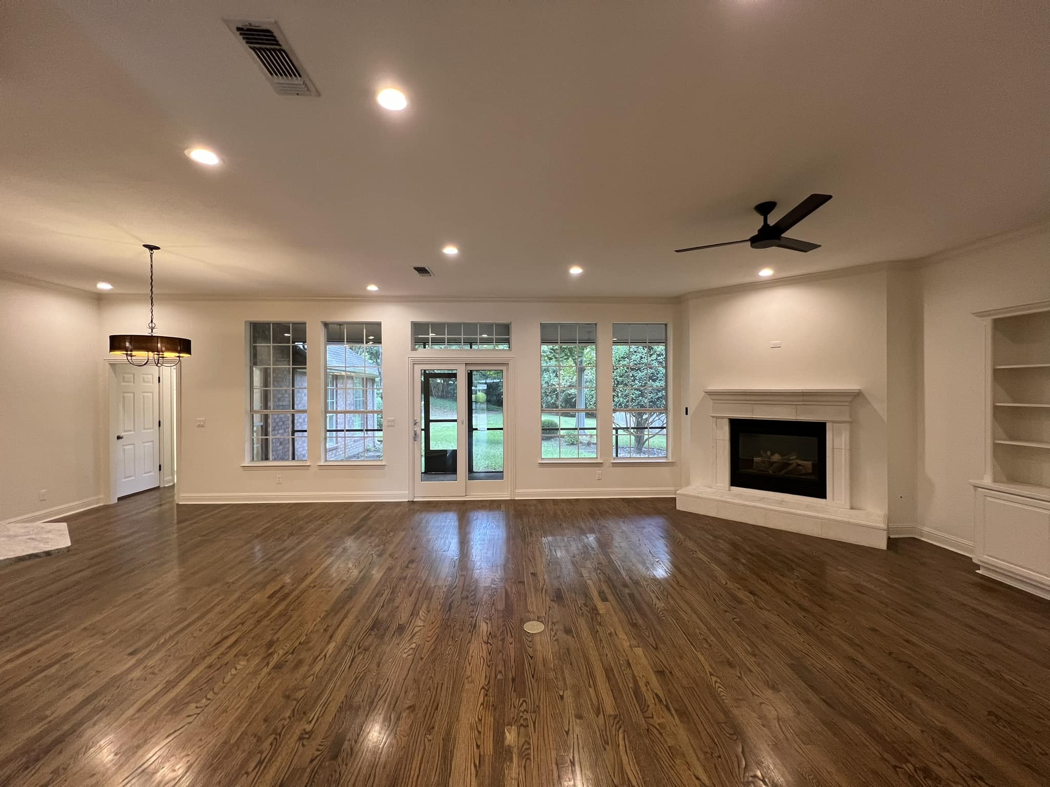 Open living room renovation with hardwood floors, fireplace and fresh paint in Fort Worth